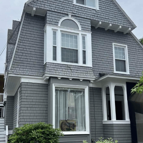 A beautifully painted blue house exterior with white trim.